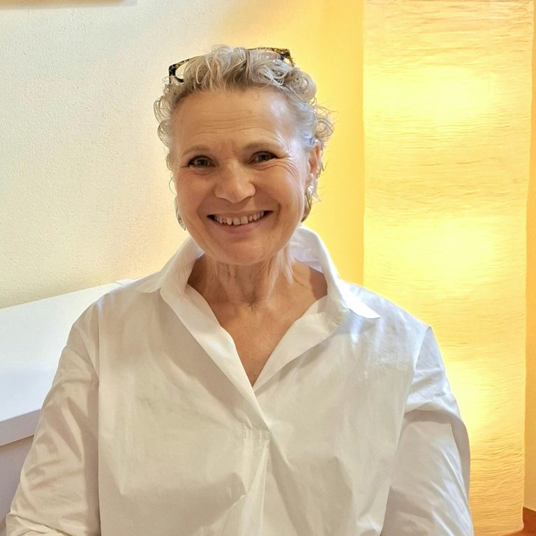 Sabine Erber, Psychosoziale Beratung, Eheberatung, Mediation, Angeordnete Beratung im Pongau Sabine Erber, sitzt in ihrer Praxis "Aufwerts" mit Dekoration im Hintergrund.